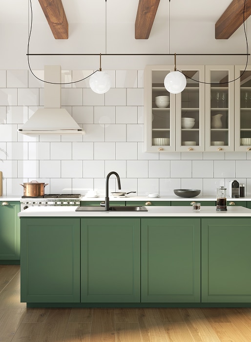 Cuisine moderne lumineuse avec armoires inférieures vertes, comptoirs blancs et carrelage métro blanc. Des poutres en bois et un éclairage suspendu complètent le design.