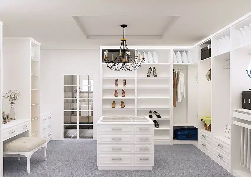 Dressing room blanc avec îlot central, étagères pour chaussures et vêtements, coiffeuse et lustre noir élégant.